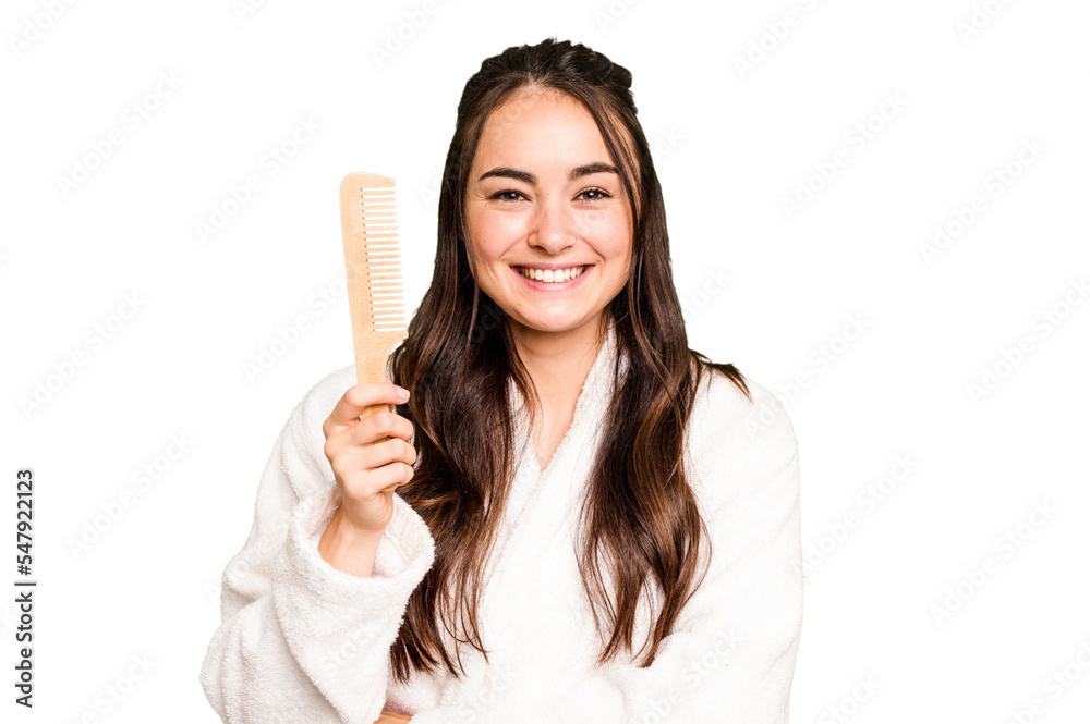 Young caucasian woman holding a hairbrush isolated on green chroma background laughing and having fun. Young caucasian woman holding a hairbrush isolated on green chroma background laughing and having fun.