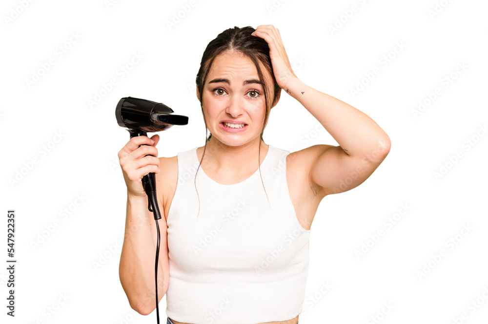 Young caucasian woman holding a hairdryer on green chroma background being shocked, she has remembered important meeting. Young caucasian woman holding a hairdryer on green chroma background being shocked, she has remembered important meeting.