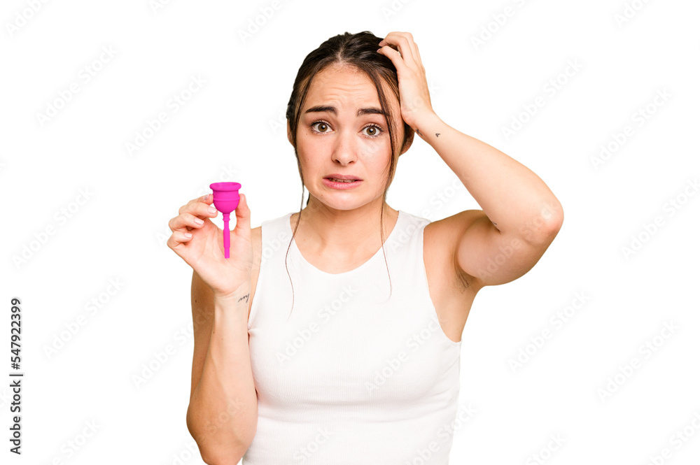 Young caucasian woman holding menstrual cup isolated on green chroma background being shocked, she has remembered important meeting. Young caucasian woman holding menstrual cup isolated on green chroma background being shocked, she has remembered important meeting.