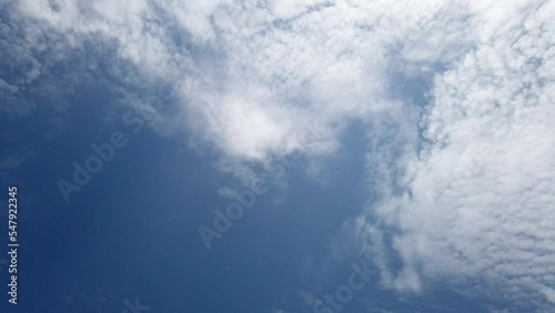 White fluffy and beautiful cumulus clouds like a cotton  freedom slowmotion tranform to many shape on blue sky  in daytime  with sunshine ray nature move from left bottom to top right time lapse