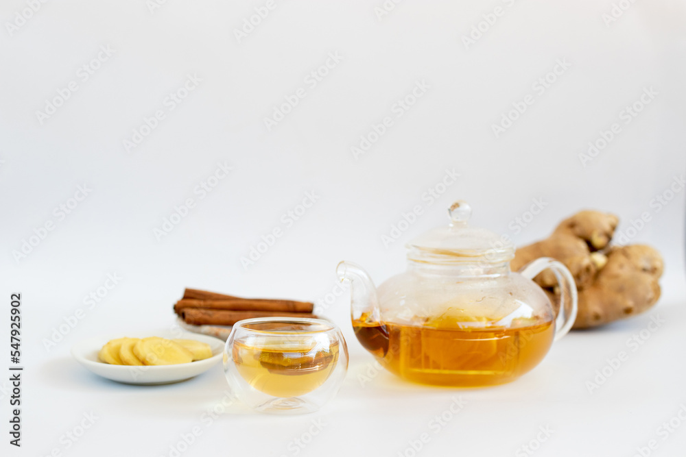 a cup of tea with ginger root, lime, cinnamon and teapot on white background. Health drink concept.. a cup of tea with ginger root, lime, cinnamon and teapot on white background. Health drink concept..