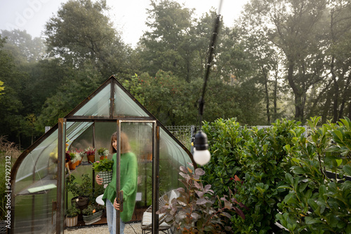 Woman with plants in greenhouse