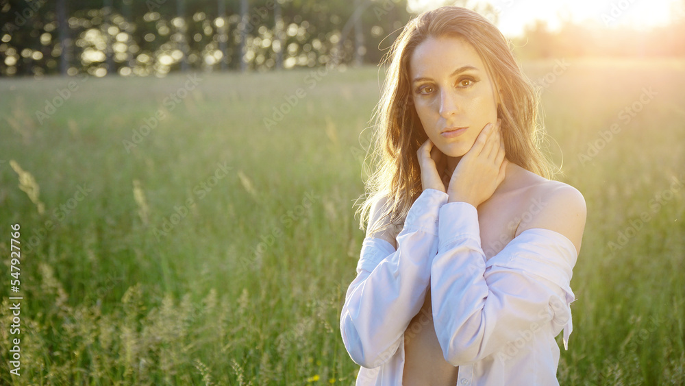 Young brunette woman on a field on a sunny day in summer Young brunette woman on a field on a sunny day in summer