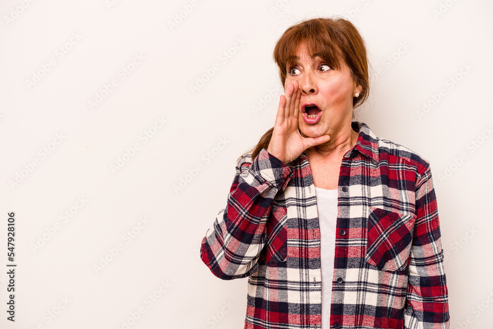 Middle age caucasian woman isolated on white background is saying a secret hot braking news and looking aside