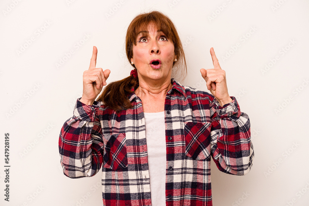 Middle age caucasian woman isolated on white background pointing upside with opened mouth.