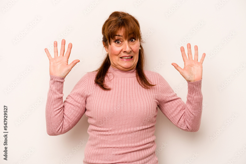 Middle age caucasian woman isolated on white background being shocked due to an imminent danger Middle age caucasian woman isolated on white background being shocked due to an imminent danger