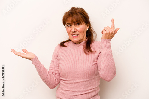 Middle age caucasian woman isolated on white background holding and showing a product on hand.