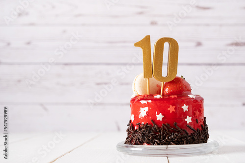 The number Ten on a red birthday cake on a light background