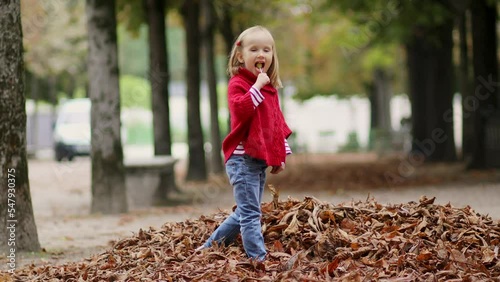 Adorable preschooler girl walking in Tuileries garden in Paris, on a fall day photo