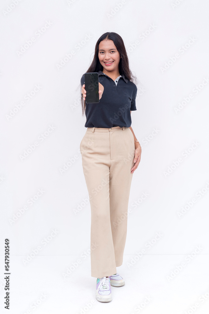 A young asian woman showing an app on her cellphone. Wearing a dark blue polo shirt, khaki pants and white sneakers. Mobile phone advertisement layout. Full body photo on a white background. A young asian woman showing an app on her cellphone. Wearing a dark blue polo shirt, khaki pants and white sneakers. Mobile phone advertisement layout. Full body photo on a white background.