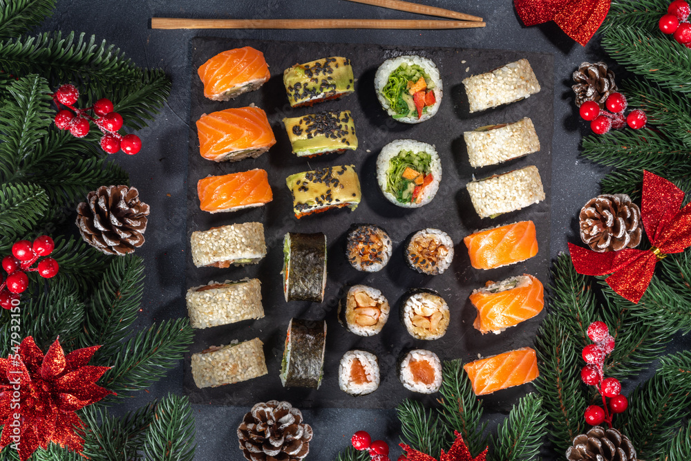 Sushi set for Christmas New Year party, winter holiday food delivery menu mockup. Sushi set on slate board, with Xmas decoration copy space