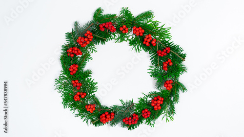 Natural branches of spruce and arborvitae are decorated with red rowan berries. Eco friendly Christmas wreath.