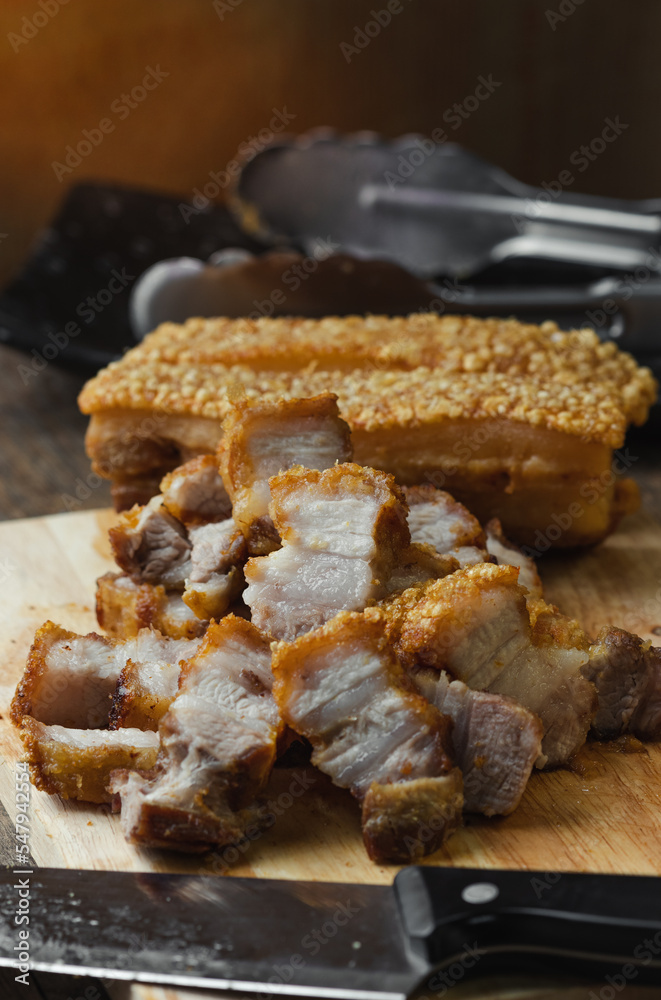 crispy pork belly deep fried pork or Chinese roasted pork belly on a wooden chopping board. close-up shot crispy pork belly deep fried pork or Chinese roasted pork belly on a wooden chopping board. close-up shot