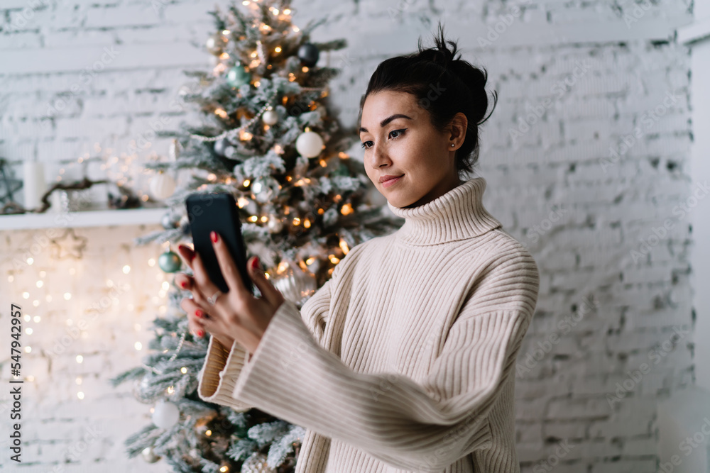 Girl take selfie on smartphone near Christmas tree Girl take selfie on smartphone near Christmas tree