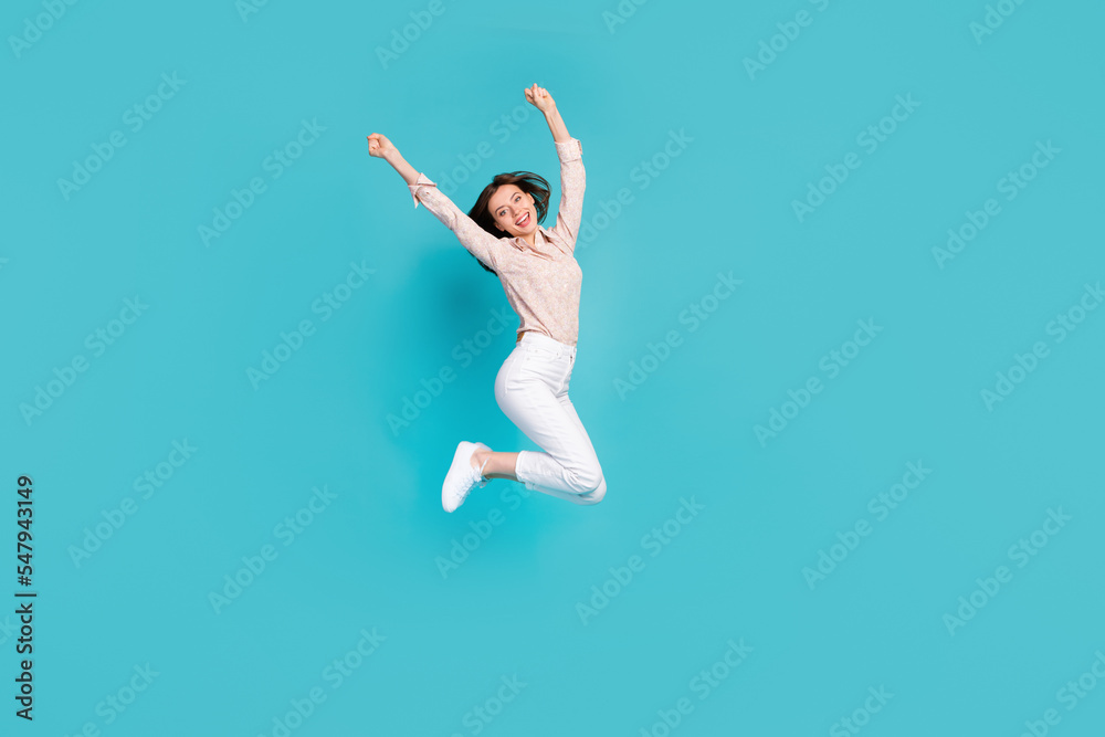 Full length photo of attractive bob brown hair lady wear office outfit jumping air trampoline arms up celebrate her weekend isolated on blue color background