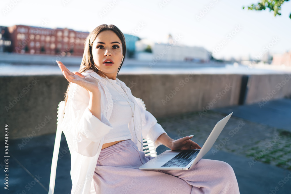 Amazed woman using netbook near embankment