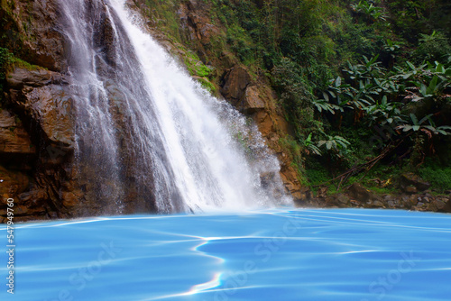 Fototapeta Naklejka Na Ścianę i Meble -  Jungle waterfall cascade in tropical rainforest with rock with blue water surface. Blue water shing.