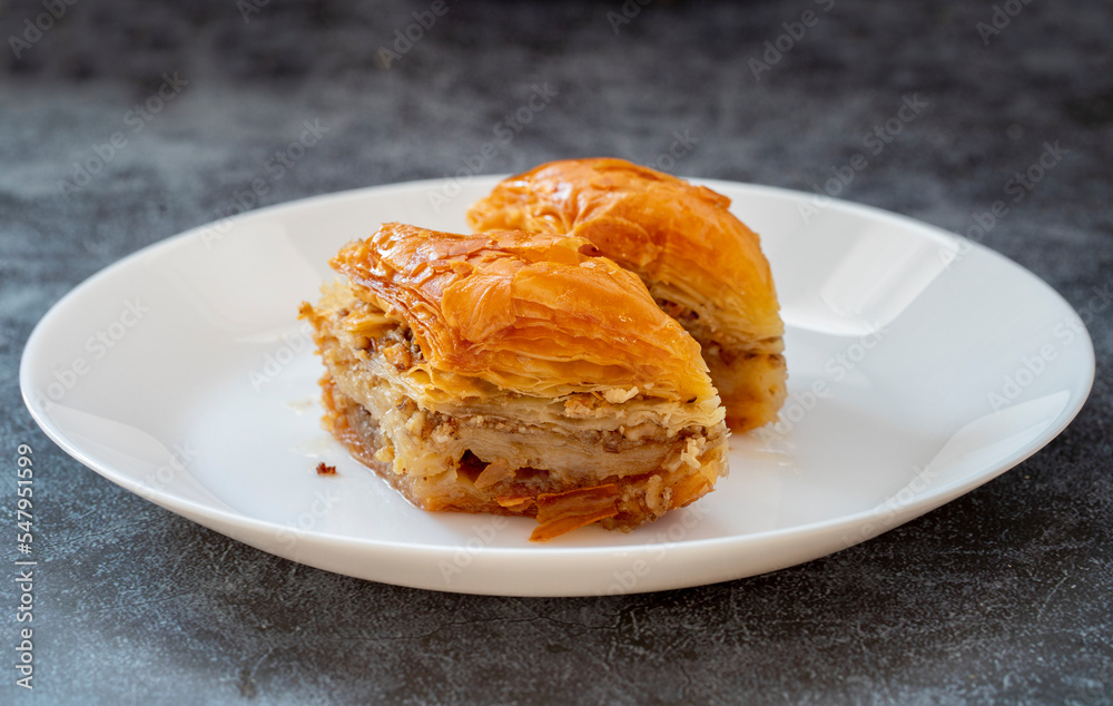 Baklava with pistachio in a white plate. Turkish style pistachio baklava presentation and service. Horizontal view. Baklava with pistachio in a white plate. Turkish style pistachio baklava presentation and service. Horizontal view.