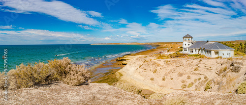 Panoramic over beautiful and colorful at sunset Atlantic coastline near peninsula Valdes, Puerto Madryn city with sandstone cliffs at low tide with alga, seashells and caves, Patagonia, Argentina photo