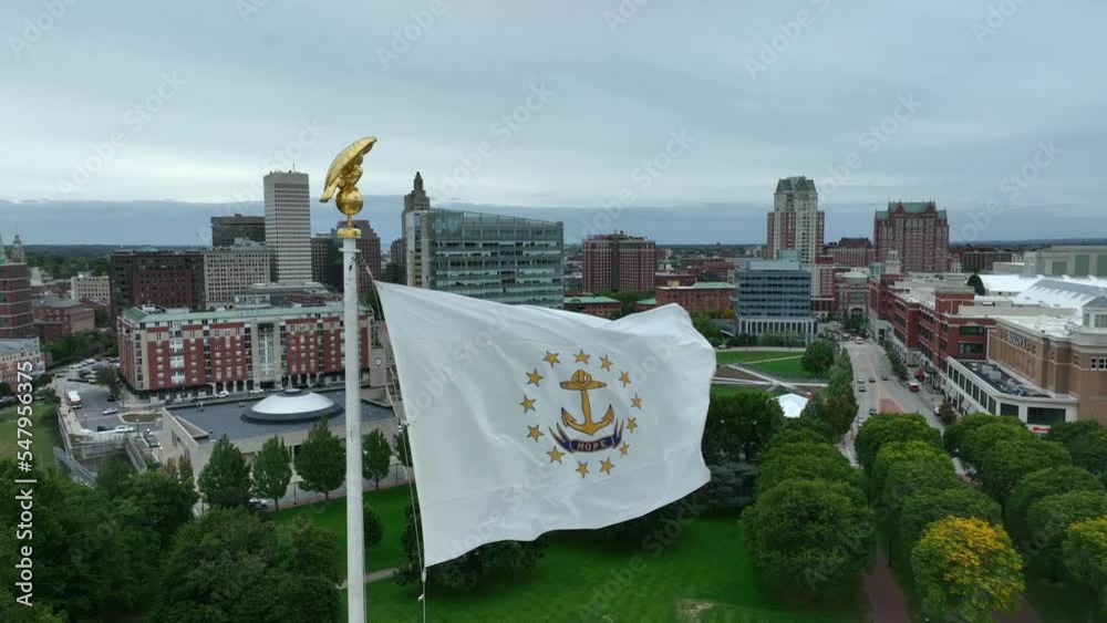 State flag of Rhode Island. RI USA is small state in United States. Aerial establishing shot of urban city.