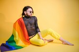 Gay man hold rainbow striped flag isolated on colored background studio portrait. People lifestyle fashion lgbtq concept