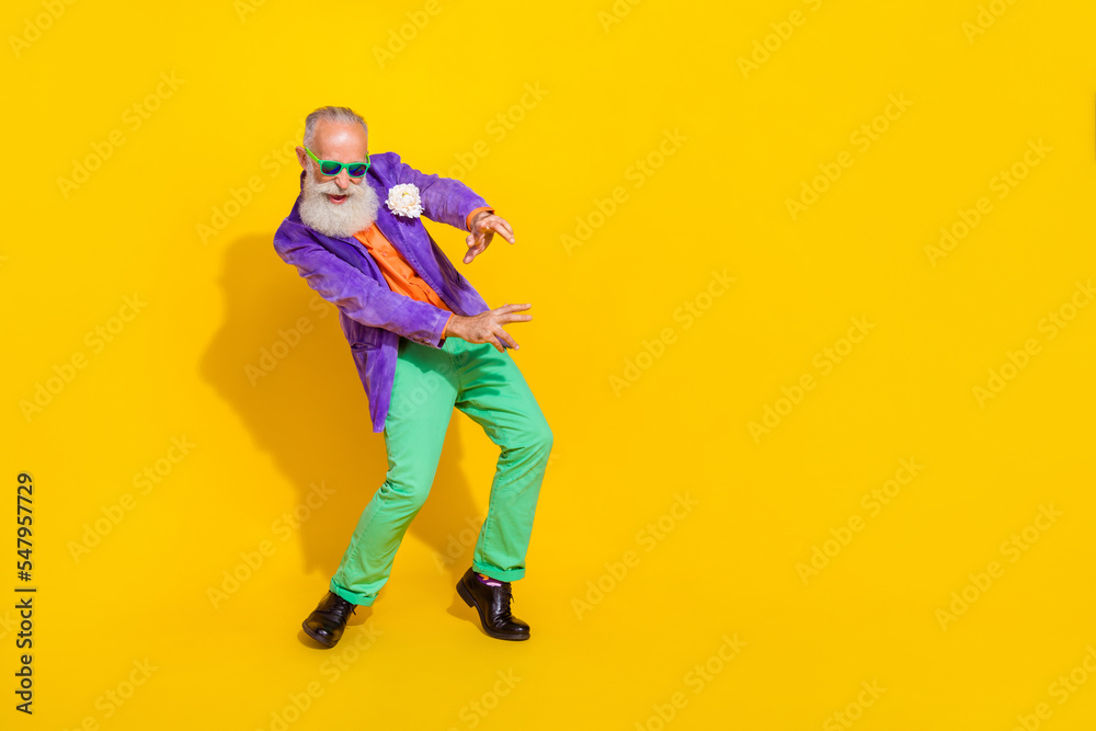 Full length photo of cheerful attractive man wear purple velvet jacket having fun discotheque empty space isolated yellow color background Full length photo of cheerful attractive man wear purple velvet jacket having fun discotheque empty space isolated yellow color background