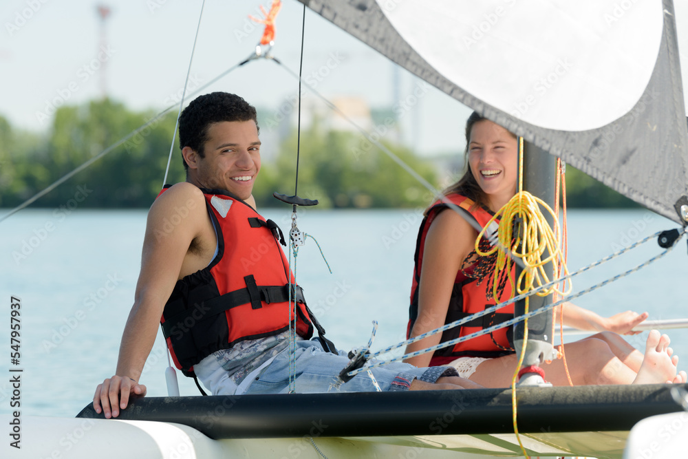 Obraz premium young couple sitting on sailboat