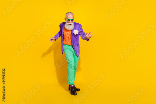 Full length photo of positive cheerful guy dressed violet velvet jacket having fun disco isolated yellow color background