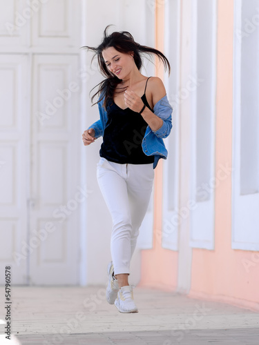 Young elegant lady outdoor lifestyle posing. Attractive beautiful girl on a city street.