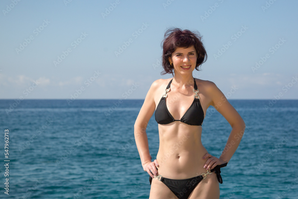 An adult woman with slim figure in a bikini. Appearance care concept.