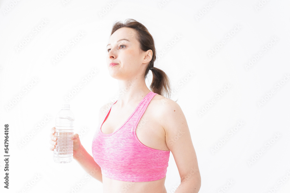 スポーツウェアを着て水分補給をする外国人の女性 スポーツウェアを着て水分補給をする外国人の女性
