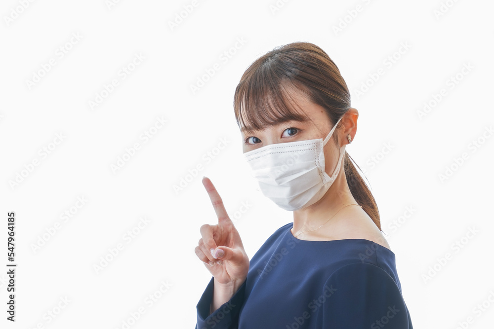 マスクを装着して指を指す若い女性 マスクを装着して指を指す若い女性