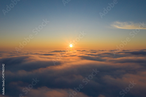 the sun rises above the clouds