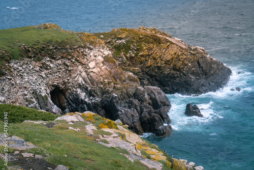 Seascpae of waves are crushing against rocky cliffs in Saltee Island, Ireland.