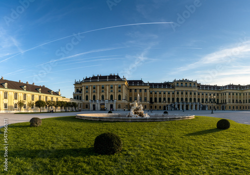 view of the front of the historic Schoenbrunn Palace in Vienna in warm evening light with a fountain in the foreground photo