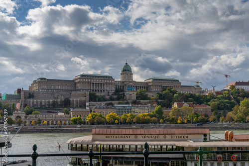 view of the Danube River and the Hungarian Parliament Building with a restaurant ship in the foreground