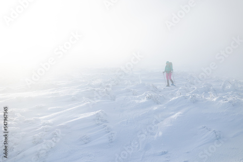 A woman in the winter trekking during the fog
