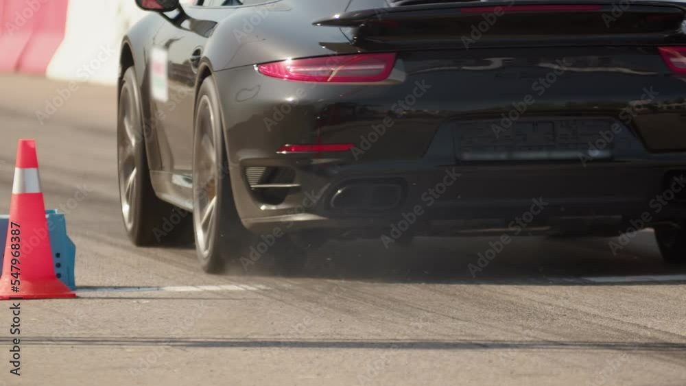 Black racing car with alloy wheels stands at the starting line and ...