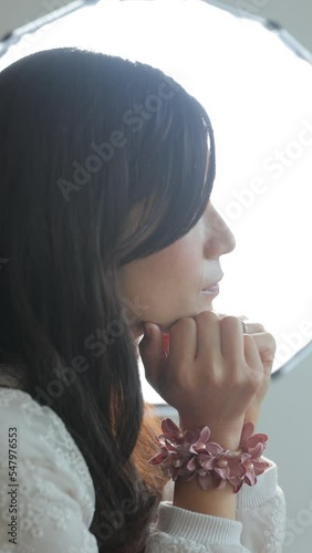 Beautiful profile of Japanese young woman in back light. Vertical. Melancholic, Loneliness, Sadness.