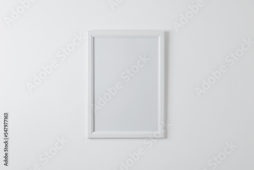 Empty picture frame mockup on clean wall. Blank surface for copy or art presentation. White wooden frame