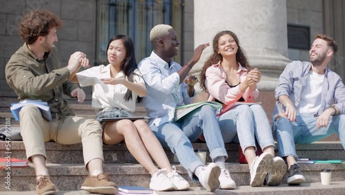 student and coed giving each other a friendly high five. slow motion.