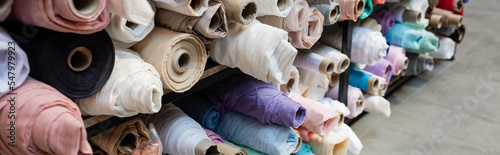 Fotografie, Tablou assortment of different fabric rolls on shelves in textile shop, banner