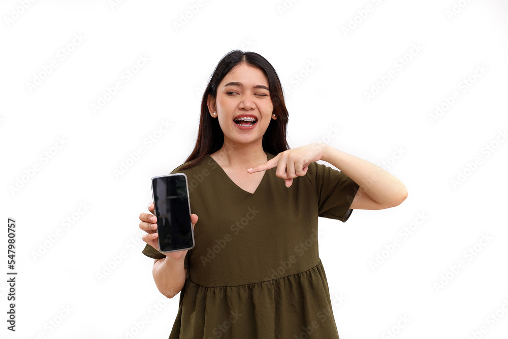 Happy young asian woman standing while showing or presenting a blank screen of her cell phone. Isolated on white Happy young asian woman standing while showing or presenting a blank screen of her cell phone. Isolated on white