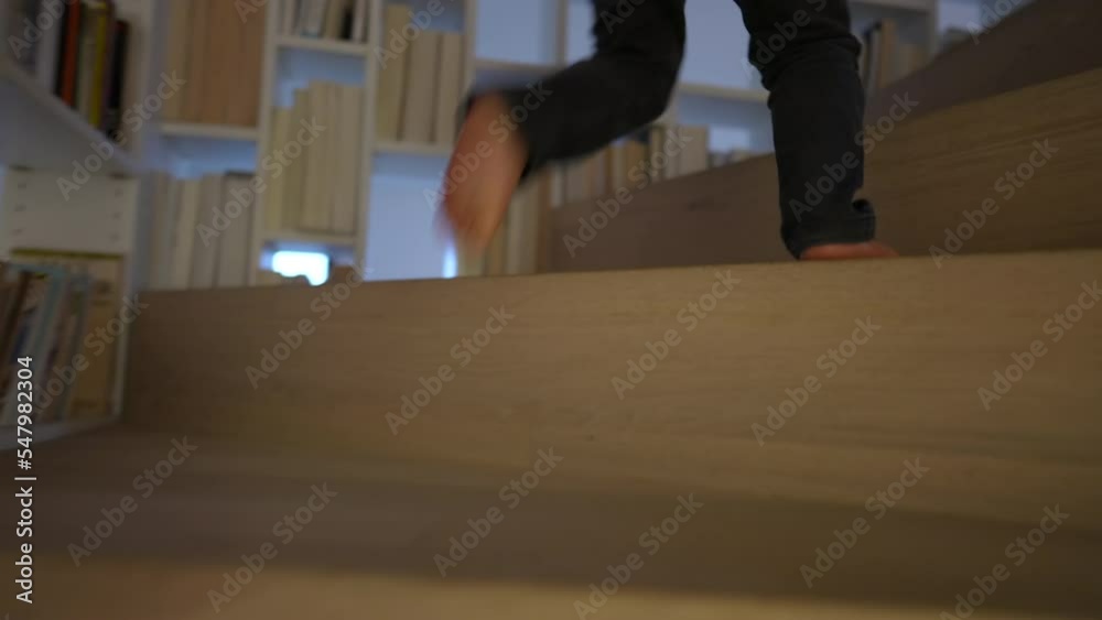 One small boy climbing stairs. Closeup child feet going up staircases at home One small boy climbing stairs. Closeup child feet going up staircases at home