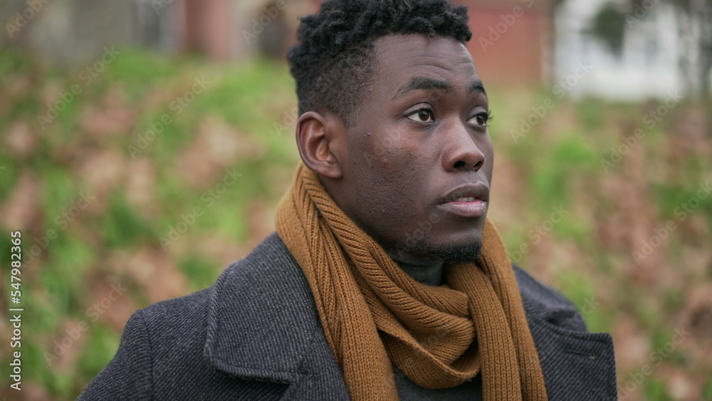 Meditative young African man standing in park during winter season Meditative young African man standing in park during winter season