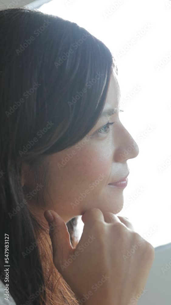 Beautiful profile of Japanese young woman in back light. Vertical. Close-up. Beautiful profile of Japanese young woman in back light. Vertical. Close-up.