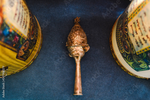 a beautifully ornate blue  case with golden bells and crowns (rimmonim)of a torah scroll and other decorations in a synagogue in israel sefad photo