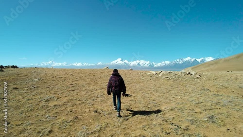 Drone view of a man walking towards the Peiku Co Lake before the Shishapangmain mountains in Tibet photo