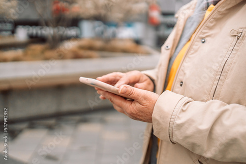 Woman using smartphone outdoors. Woman hand holding smartphone. © Shi 