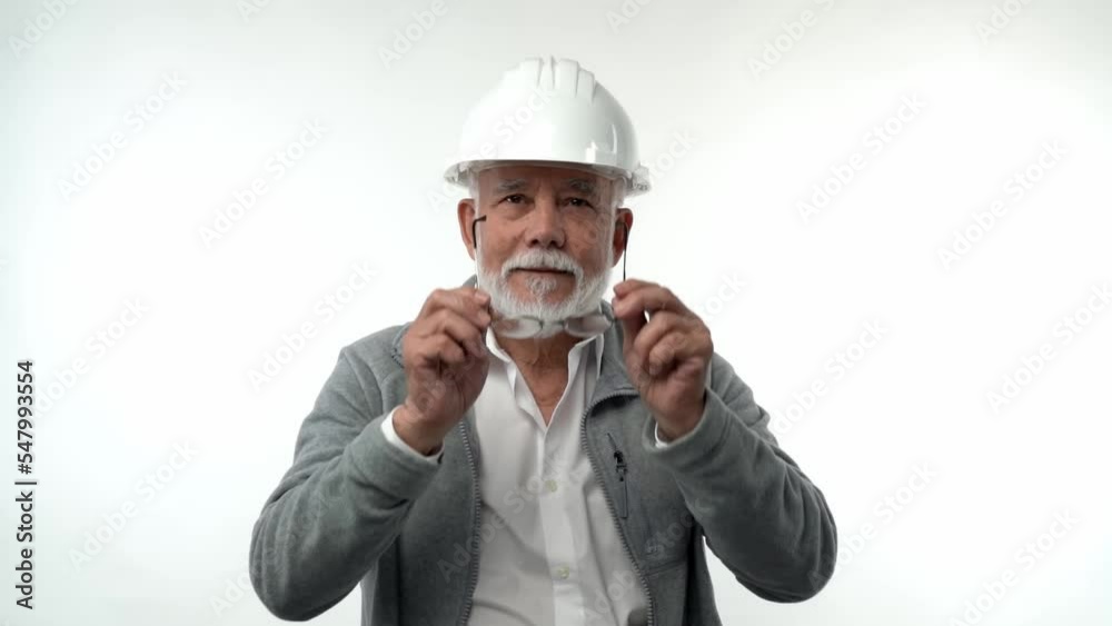 An elderly male engineer head in a white hard hat takes off his goggles. Nice white Caucasian male.